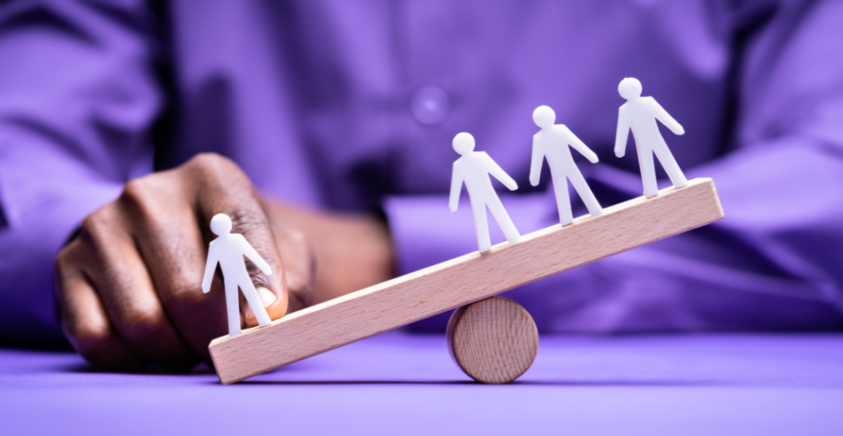 see saw with paper stick figures and man in purple shirt in background